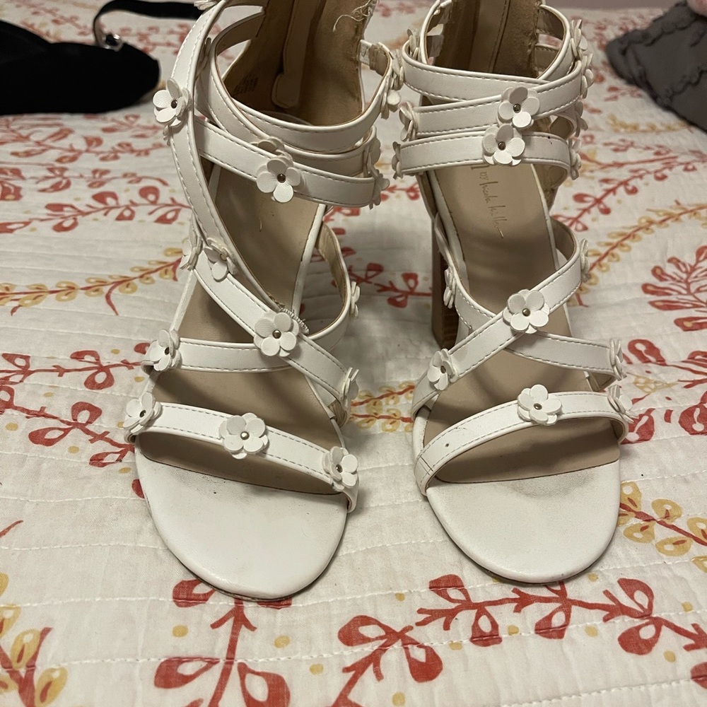 White floral heels with a broken strap
